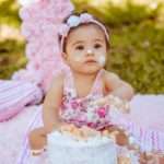 photo of a baby playing with a birthday cake